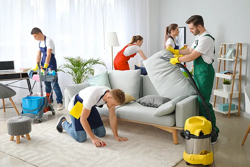 Equipo de limpieza profesional realizando limpieza residencial en una casa habitada